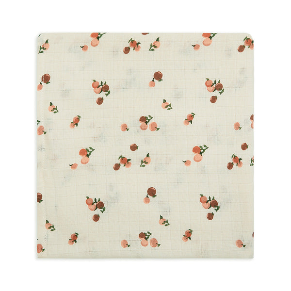 An organic cotton baby swaddle muslin in a peaches print