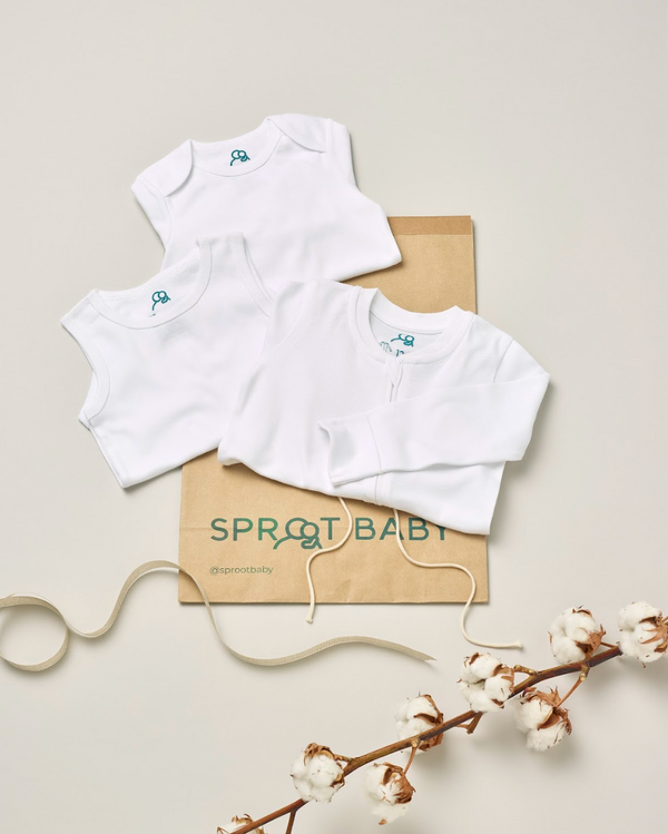 A baby essentials bundle from Sproot Baby including a sleepsuit, sleeveless body and long sleeve body all in organic cotton